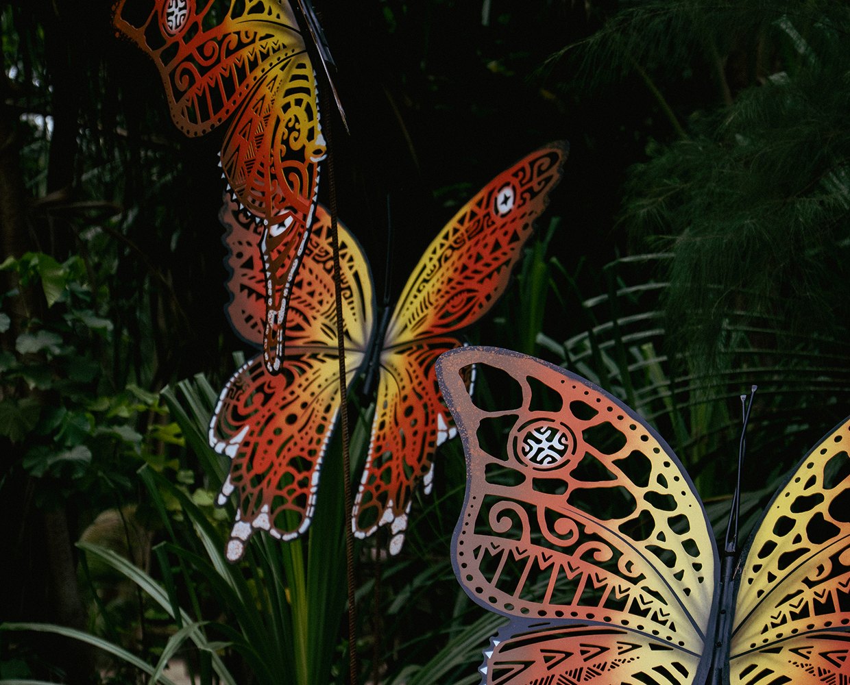 Glowing butterfly sculpture amid the vegetation