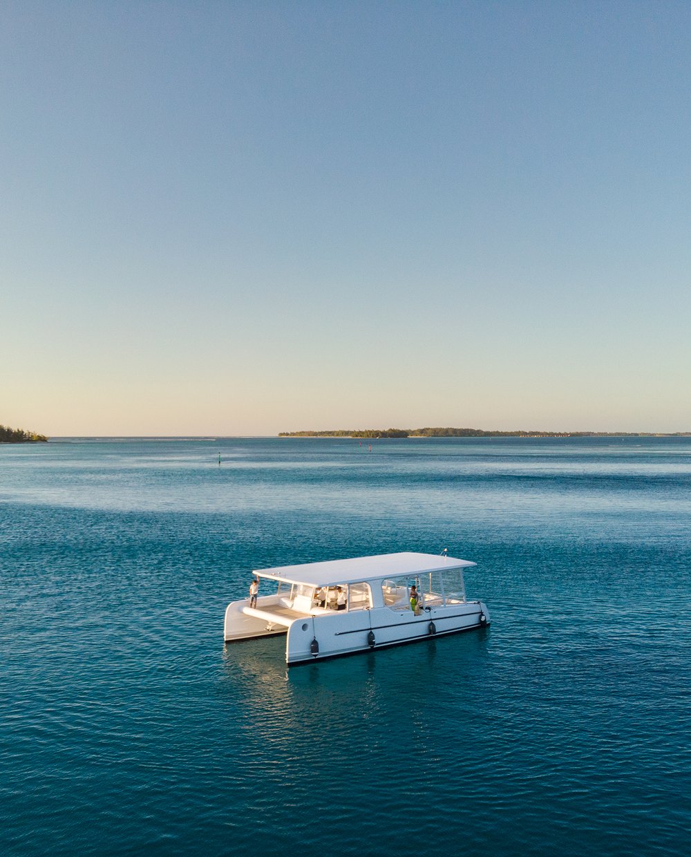 Solar catamaran on the lagoon at dusk
